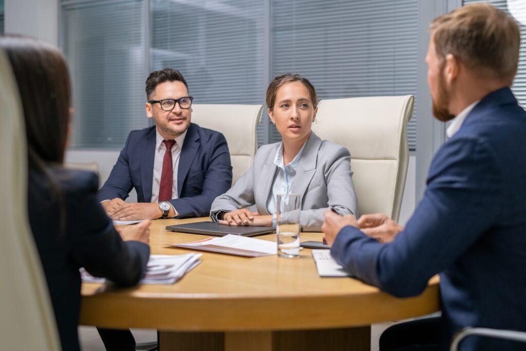 Group of young colleagues discussing working points at meeting in boardroom